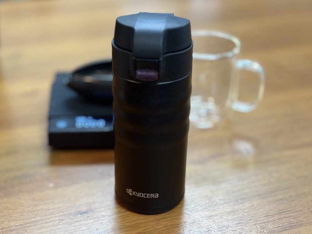 木のテーブルに置いた京セラ CERAMUG のコーヒーボトル（ブラック）